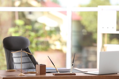 Table with scales of justice in lawyer's office