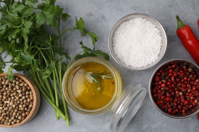 Photo of Aromatic peppercorns and different fresh ingredients for marinade on grey table, flat lay