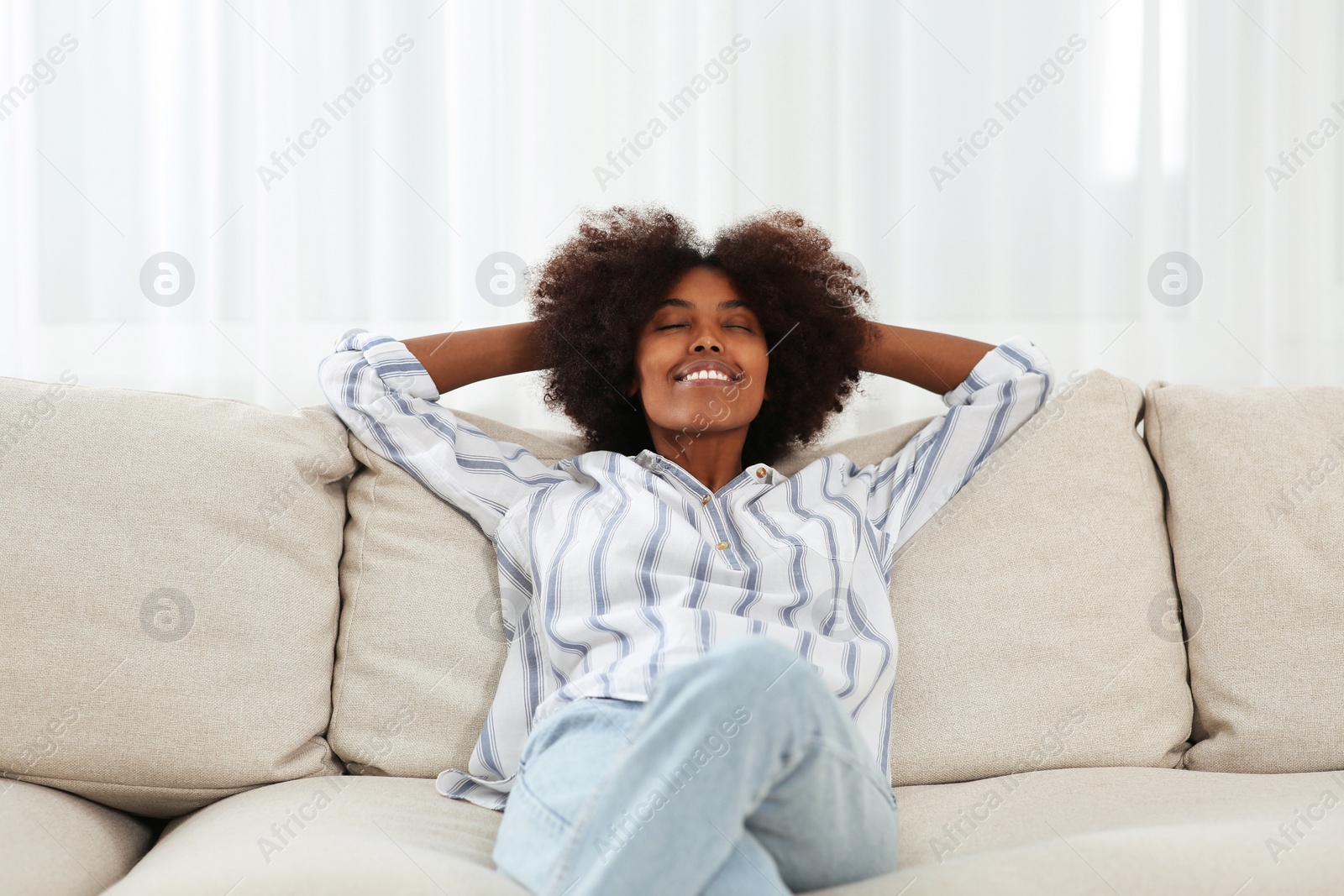 Photo of Smiling African American woman on sofa at home