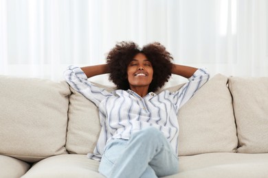 Photo of Smiling African American woman on sofa at home