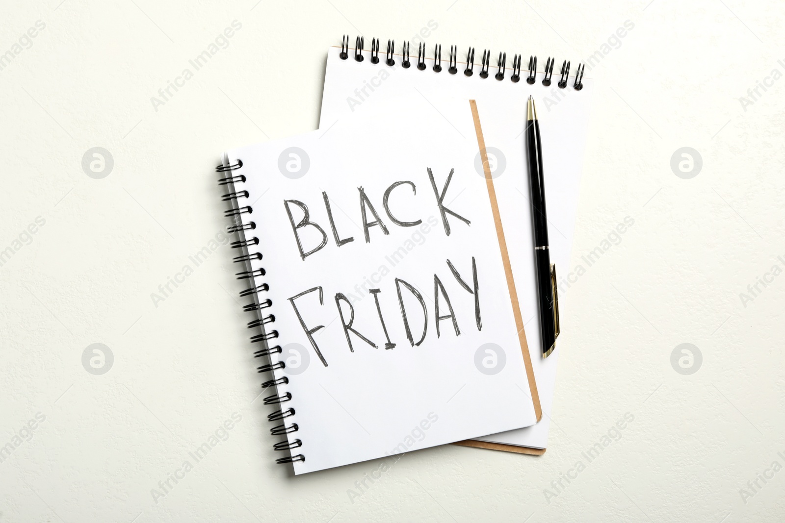 Photo of Notebook with phrase Black Friday on white background, flat lay