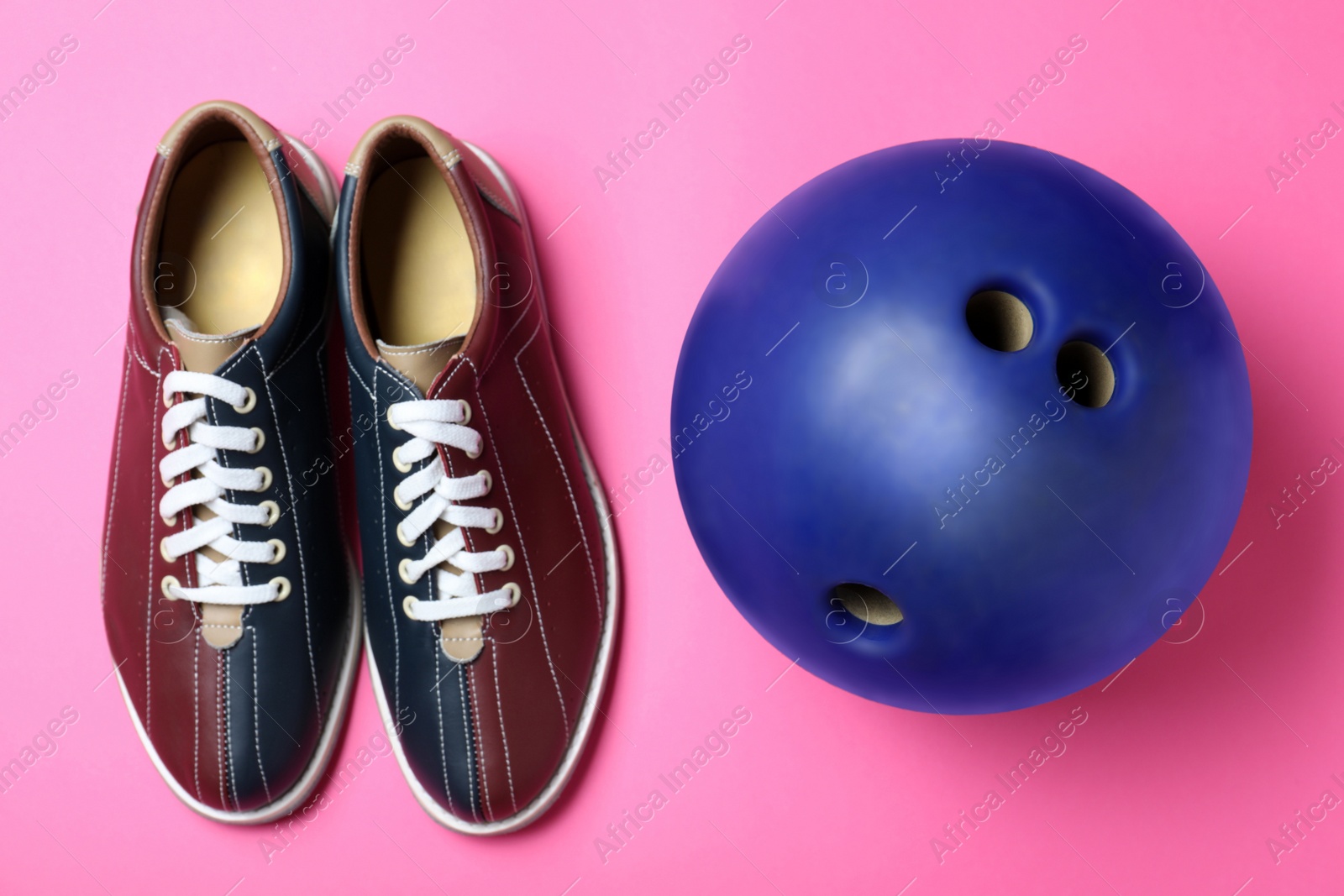 Photo of Bowling ball and shoes on pink background, flat lay