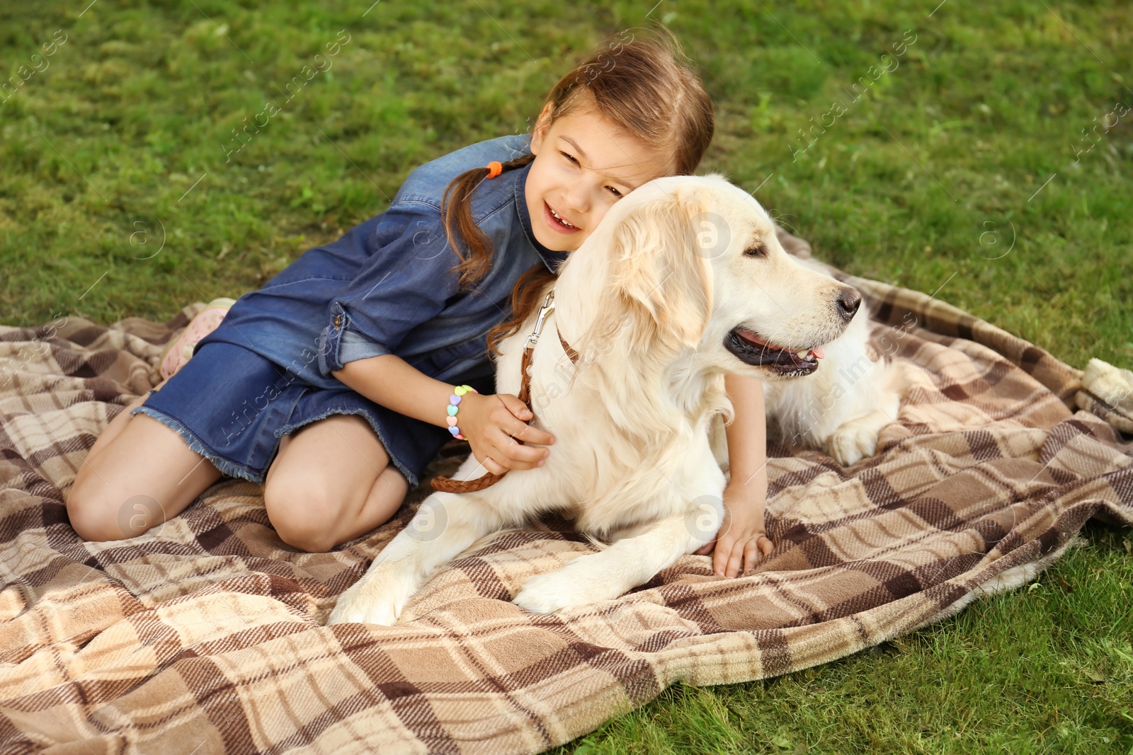 Photo of Cute little child with his pet in green park