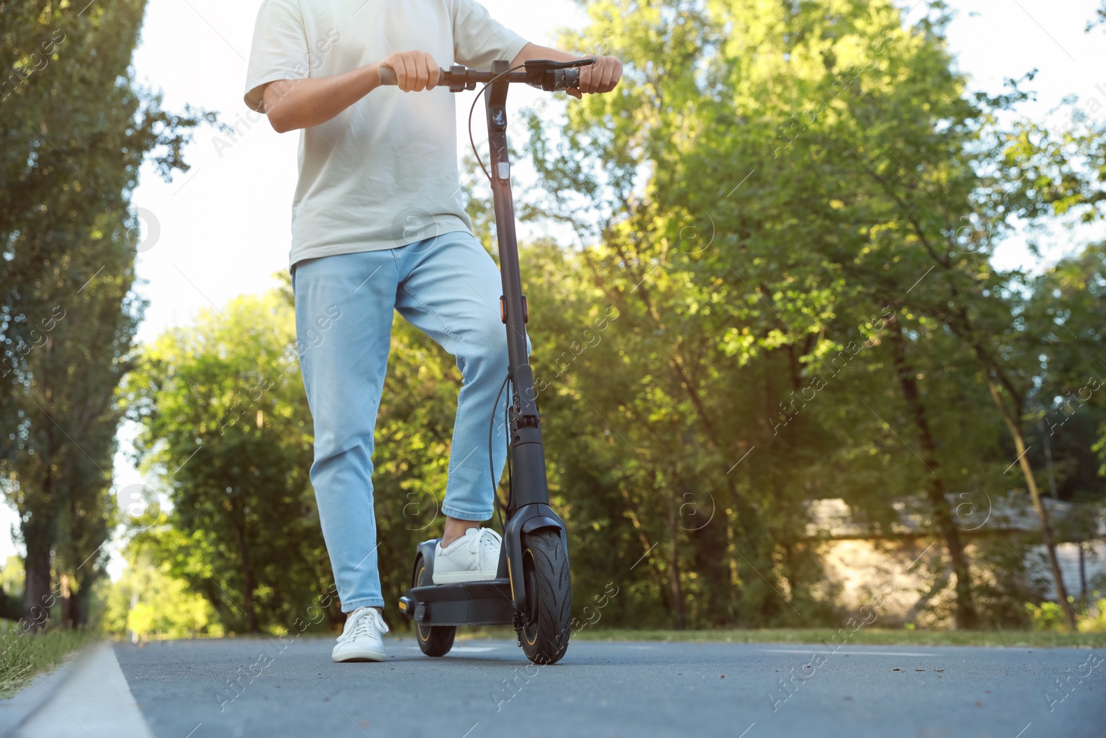 Photo of Man with modern electric kick scooter in park, closeup. Space for text