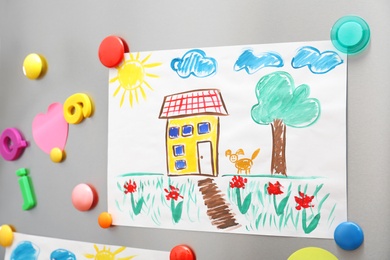 Child's drawing and magnets on refrigerator door as background