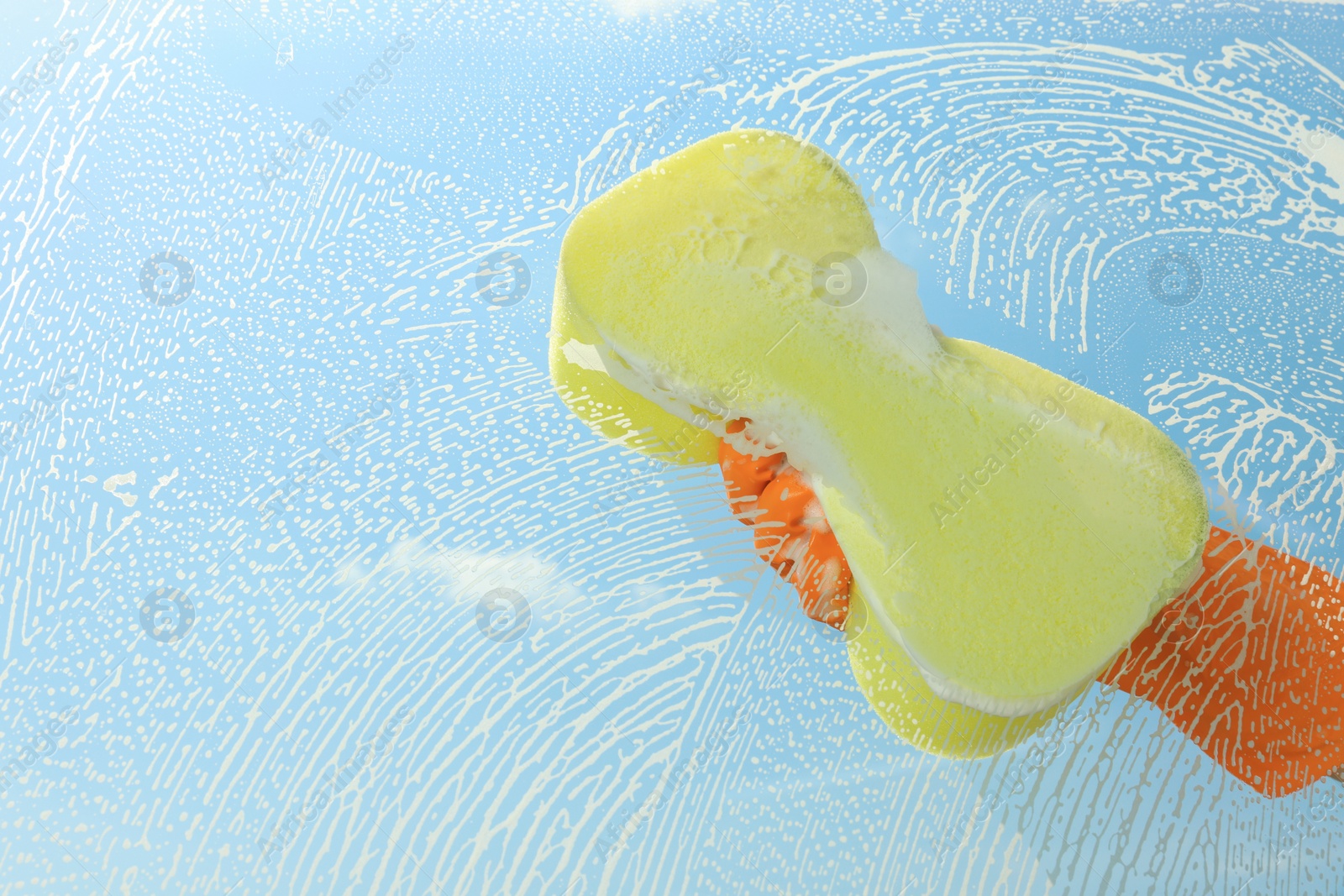 Photo of Person cleaning glass with sponge, view from inside