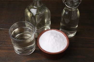 Photo of Vinegar and baking soda on wooden table