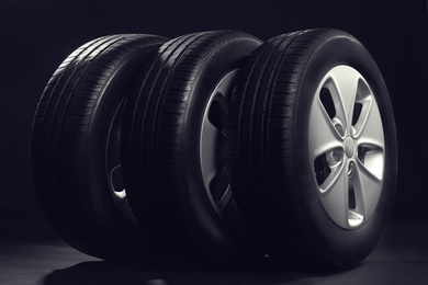 Photo of New car tires with rims on black background