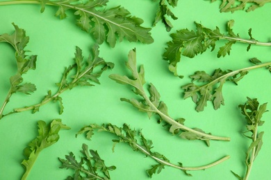 Fresh arugula on green background, flat lay