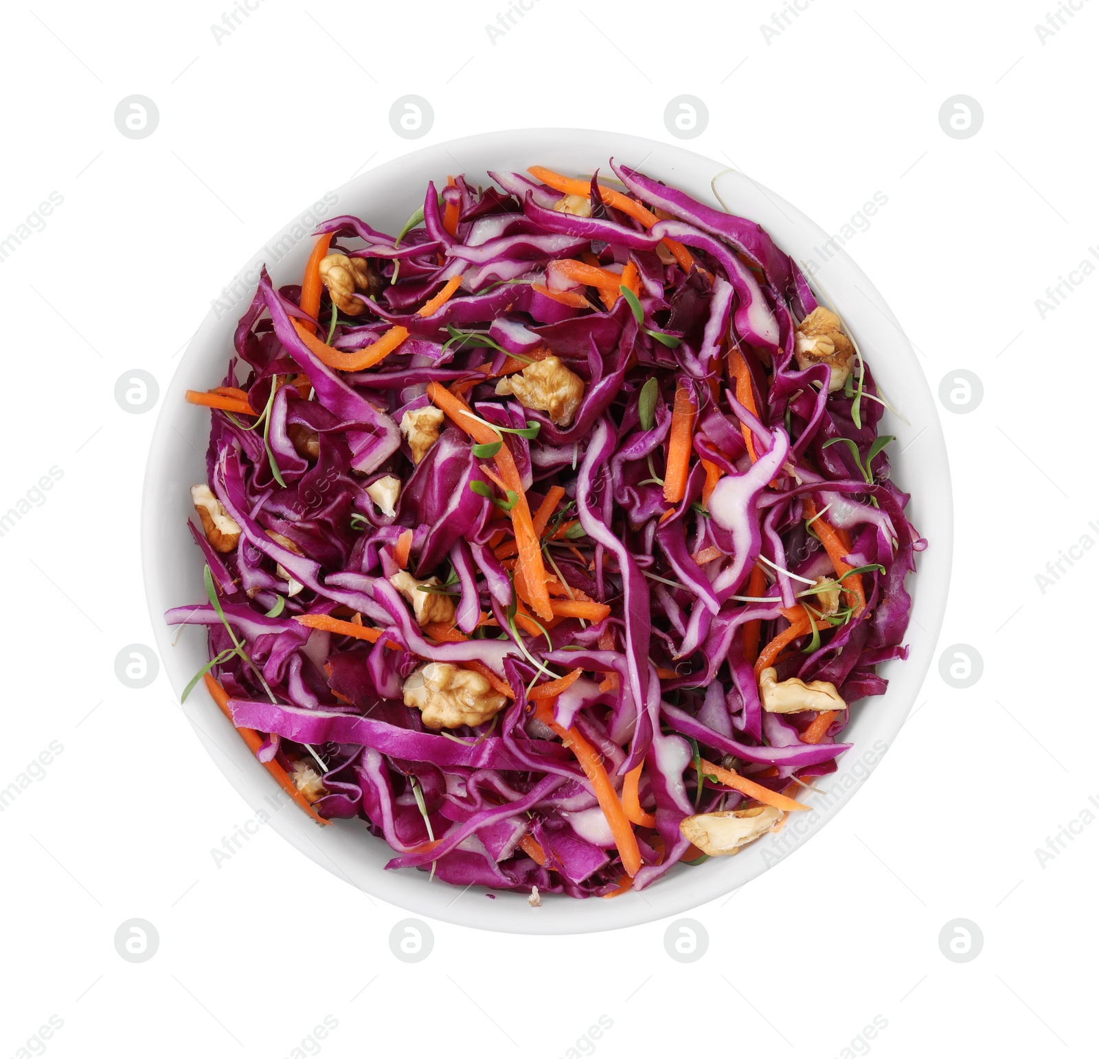 Photo of Tasty salad with red cabbage and walnuts in bowl isolated on white, top view