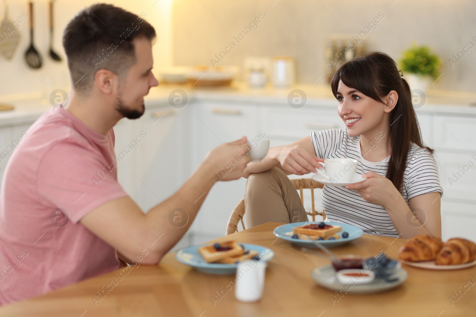 Photo of Happy couple having tasty breakfast at home