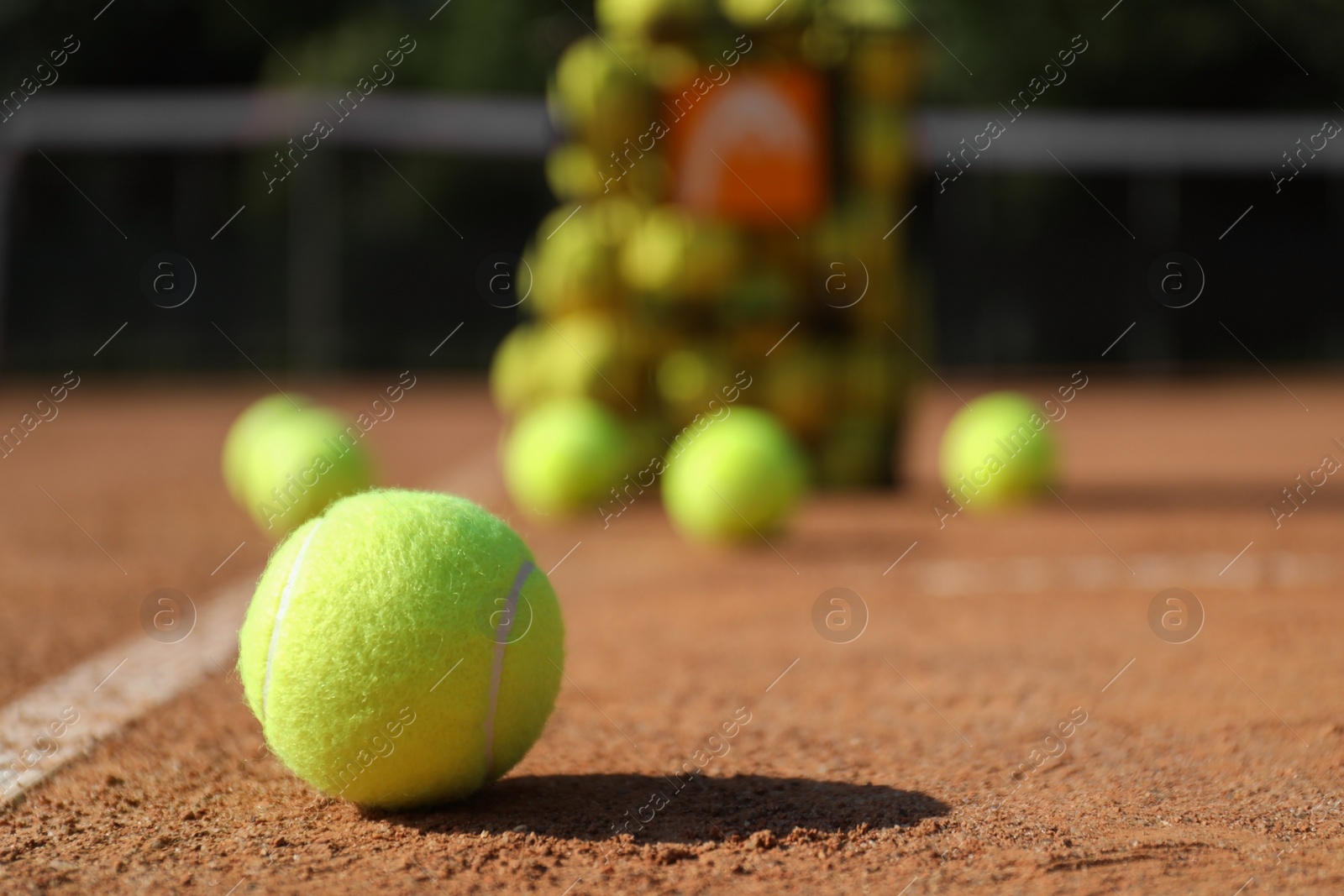 Photo of Bright yellow tennis ball on clay court