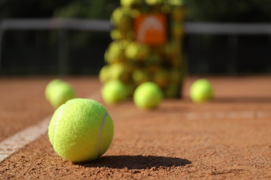 Bright yellow tennis ball on clay court