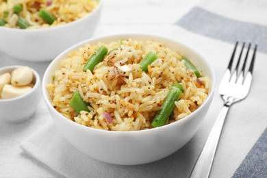 Tasty rice pilaf with vegetables on table