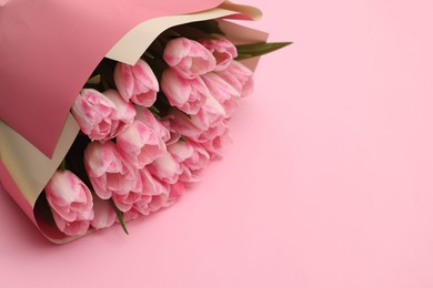 Photo of Beautiful bouquet of fresh tulips on pink background. Space for text