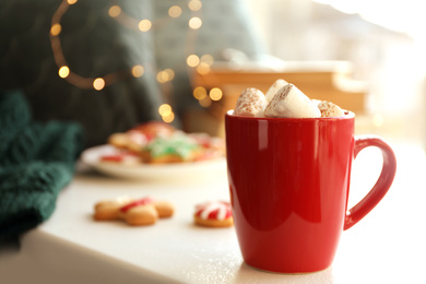 Photo of Cup of delicious hot cocoa with marshmallows on white table. Winter drink