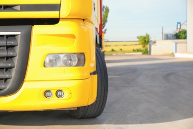 Photo of Modern yellow truck on road, closeup. Space for text