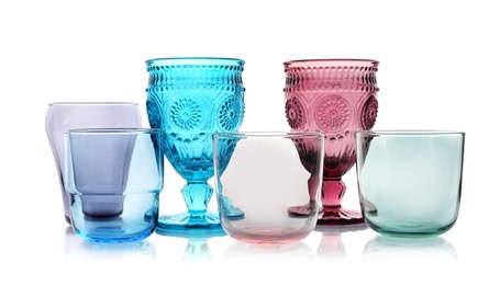 Photo of Set of colorful empty glasses on white background