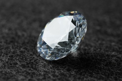 Photo of Beautiful shiny diamond on dark grey background, closeup