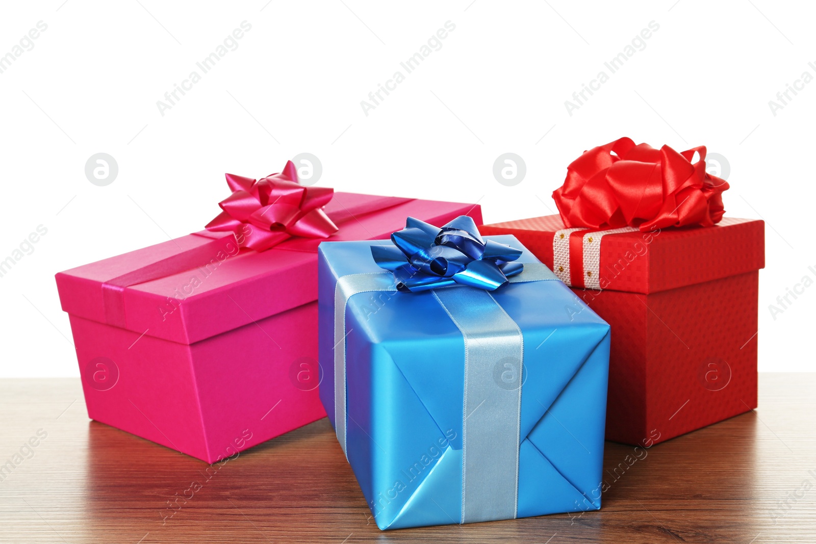 Photo of Colorful gift boxes on wooden table against white background