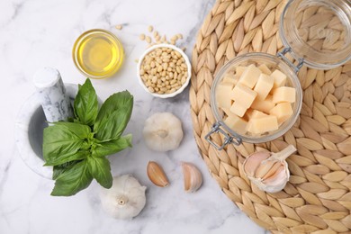 Photo of Different ingredients for cooking tasty pesto sauce on white marble table, flat lay