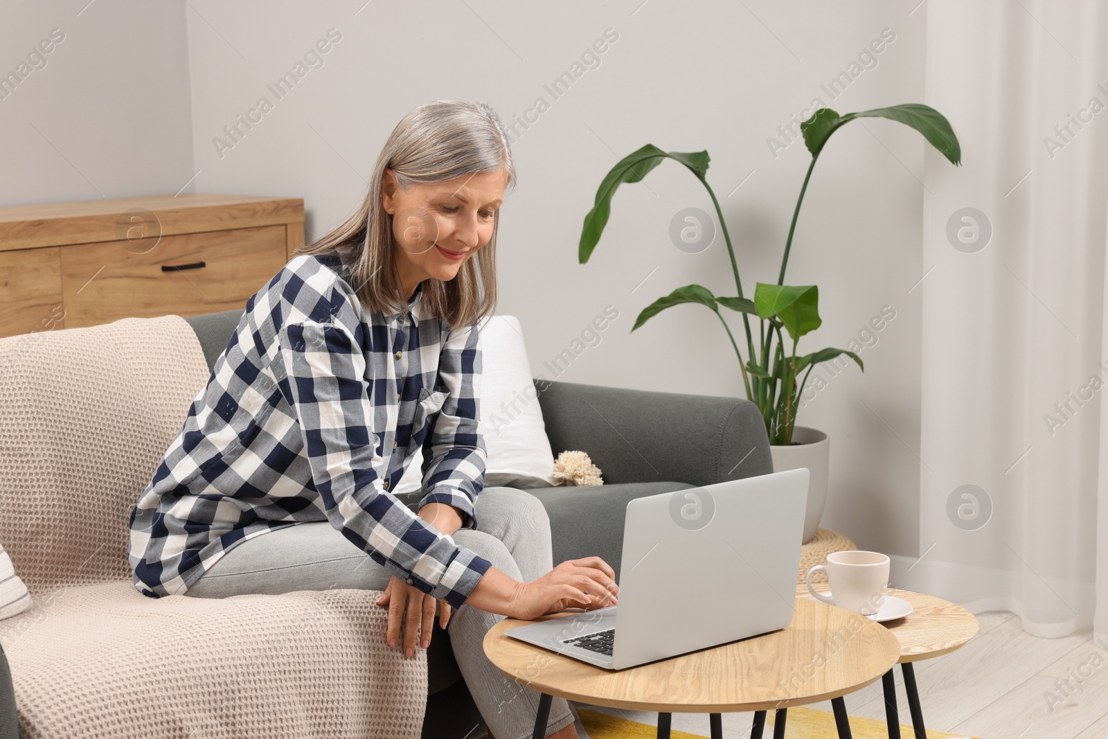 Photo of Beautiful senior woman using laptop at home