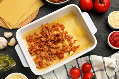 Photo of Flat lay composition with products for cooking lasagna on dark textured table