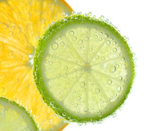 Photo of Slices of citrus fruits in sparkling water on white background, closeup