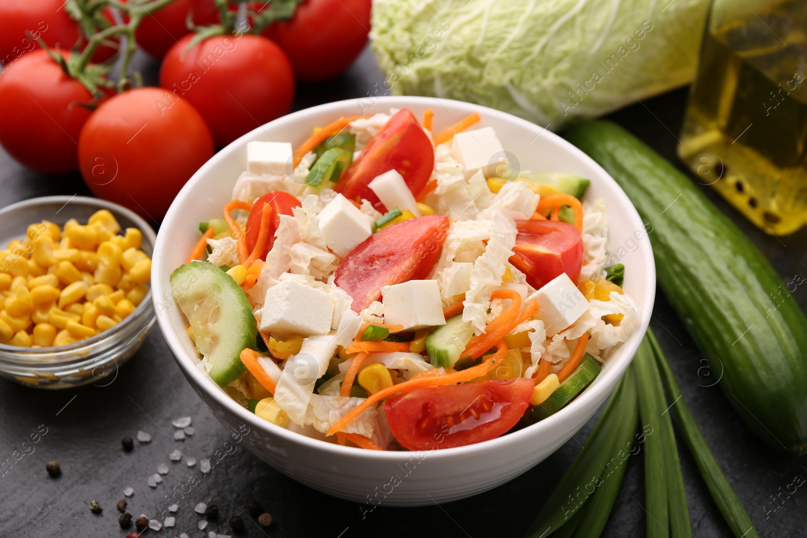 Photo of Tasty salad with Chinese cabbage served on black table