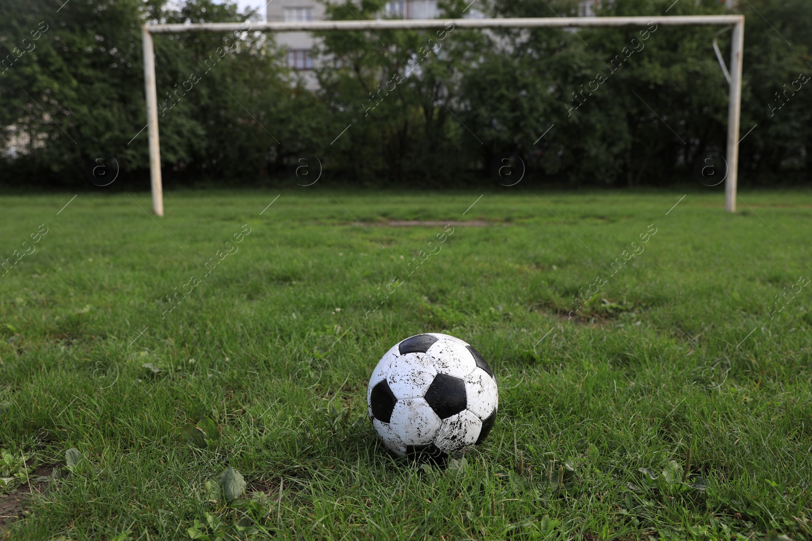 Photo of Dirty soccer ball on green grass outdoors