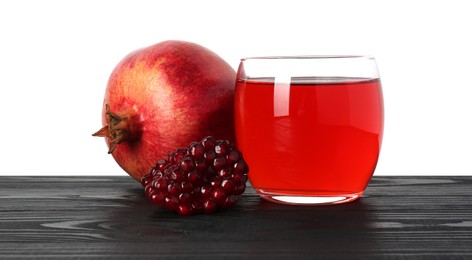 Photo of Refreshing pomegranate juice in glass, seeds and fruit on black wooden table against white background