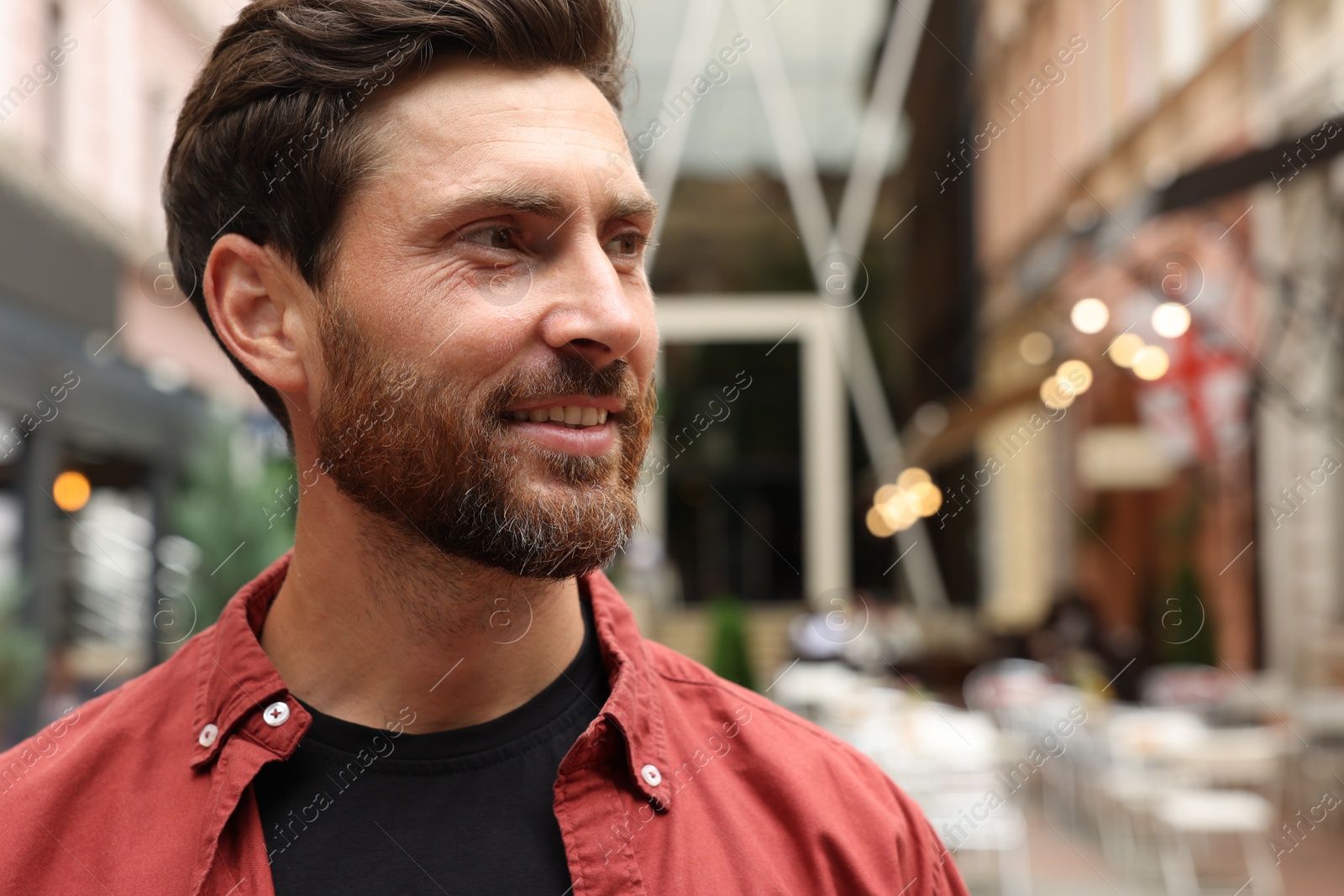 Photo of Portrait of handsome bearded man on city street, space for text