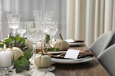 Beautiful autumn table setting. Plates, cutlery, glasses, blank cards and floral decor