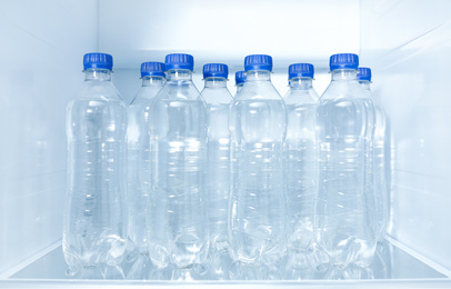 Bottles of pure water on shelf inside refrigerator