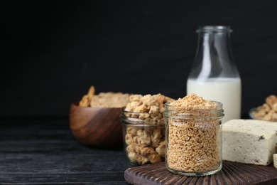 Different fresh soy products on black wooden table, space for text