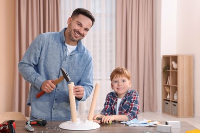 Father teaching son how to make stool at home. Repair work