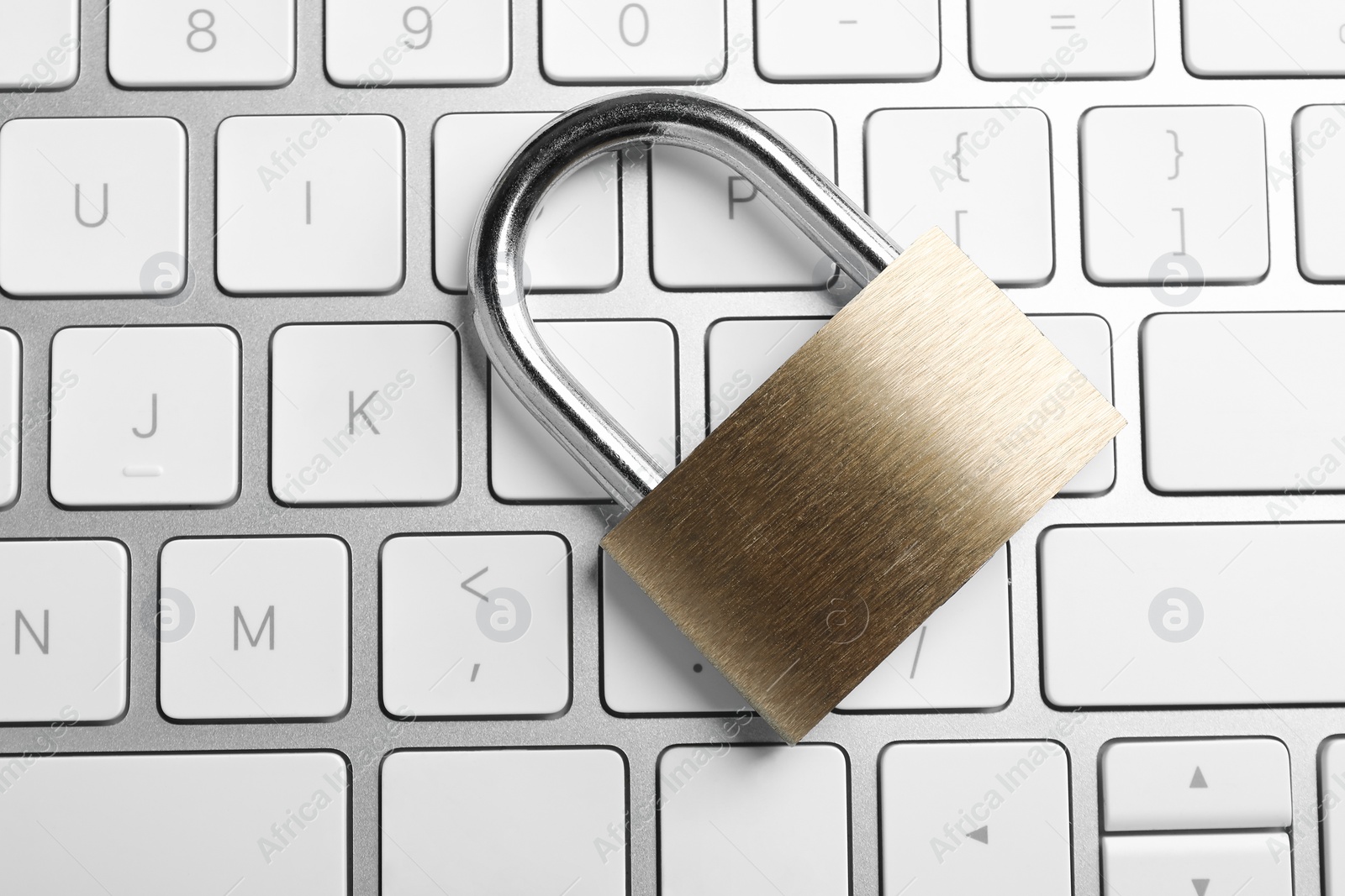 Photo of Cyber security. Metal padlock on keyboard, top view