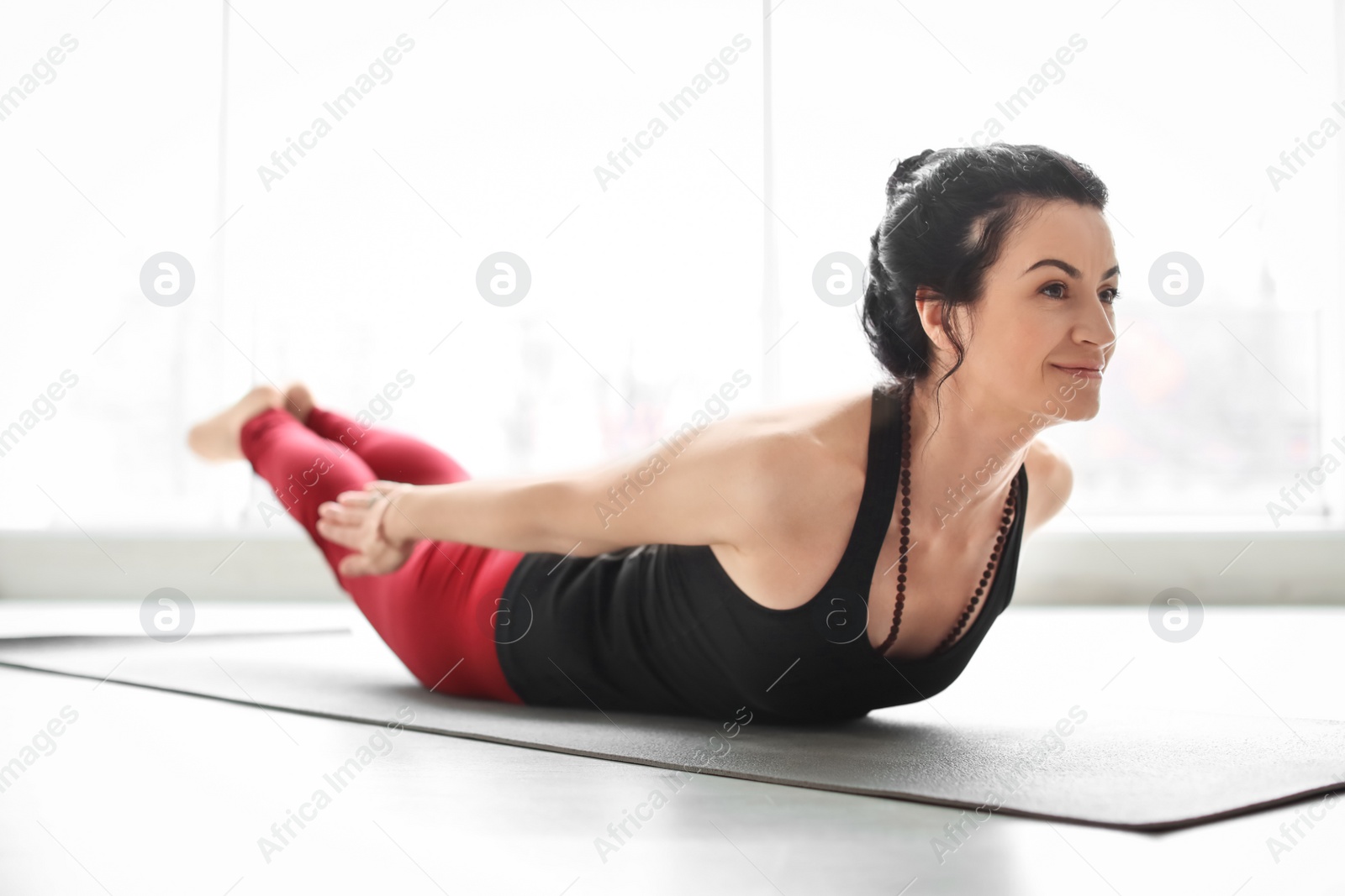 Photo of Sporty woman practicing yoga indoors