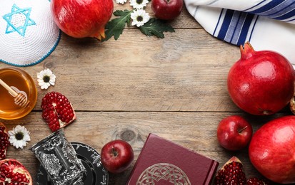 Frame of Rosh Hashanah holiday attributes on wooden table, flat lay. Space for text