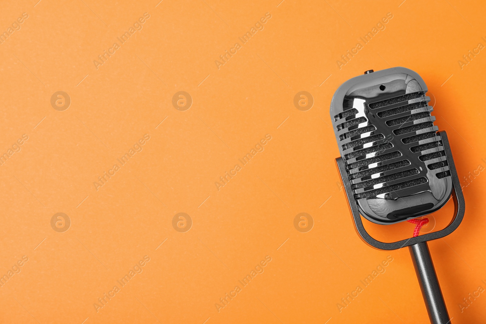 Photo of Retro microphone on color background, top view with space for text. Musical equipment