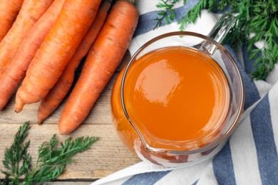 Photo of Healthy carrot juice on wooden table, top view
