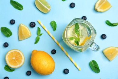 Photo of Flat lay composition with delicious natural lemonade on color background