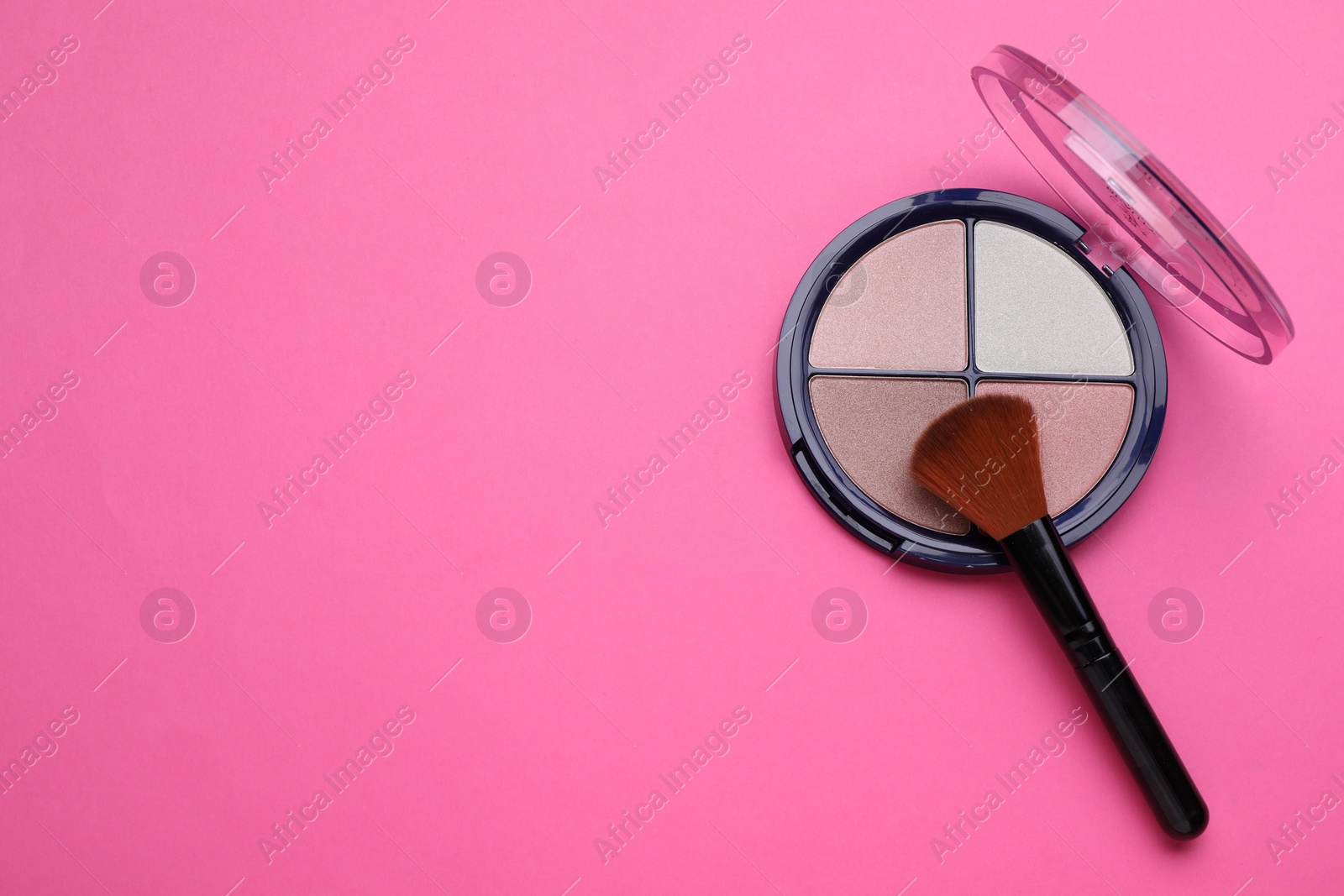 Photo of Colorful contouring palette and brush on pink background, top view with space for text. Professional cosmetic product