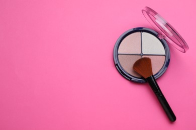 Colorful contouring palette and brush on pink background, top view with space for text. Professional cosmetic product