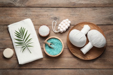 Photo of Flat lay composition with herbal massage bags and other spa products on wooden table