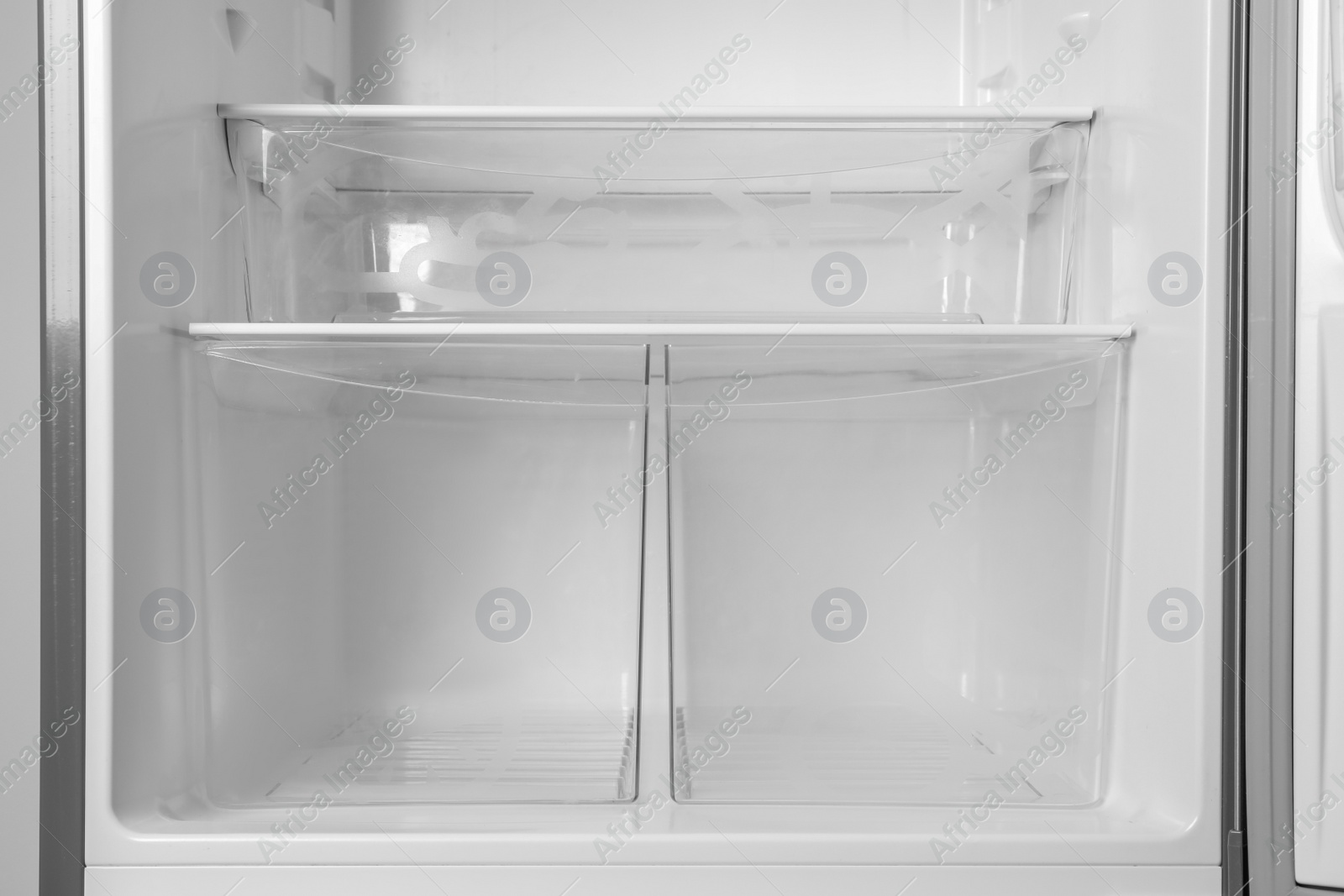 Photo of Modern open refrigerator with empty shelves, closeup