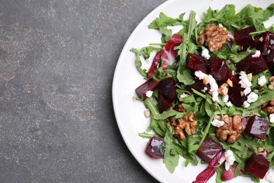 Photo of Delicious beet salad served on grey table, top view. Space for text