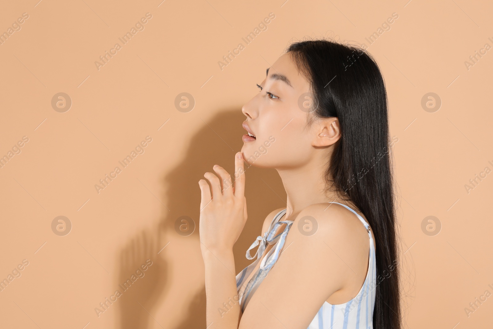 Photo of Beautiful young woman on beige background, space for text