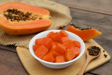 Photo of Tasty cut papaya fruits on wooden table