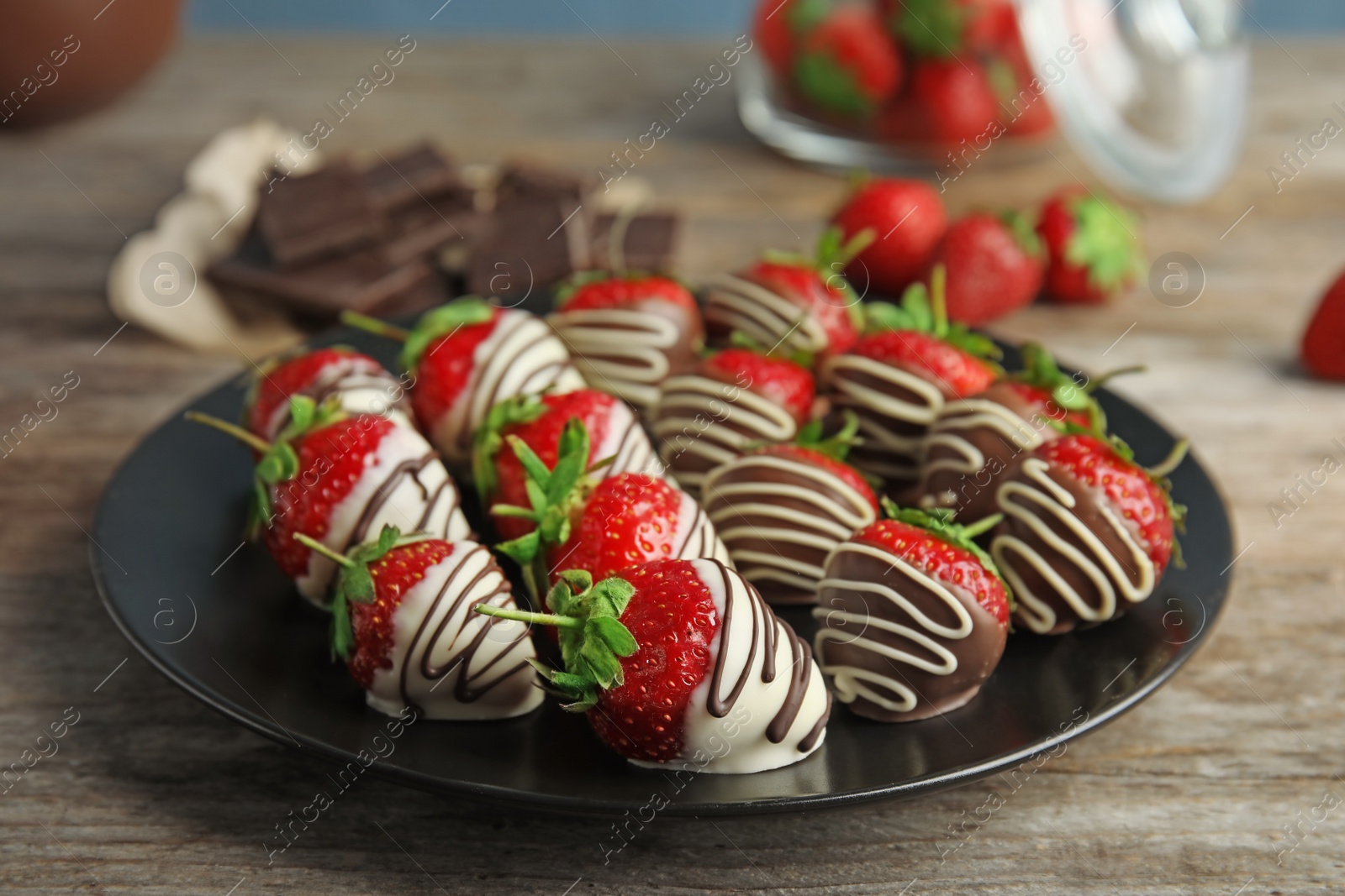 Photo of Plate with chocolate covered strawberries on table